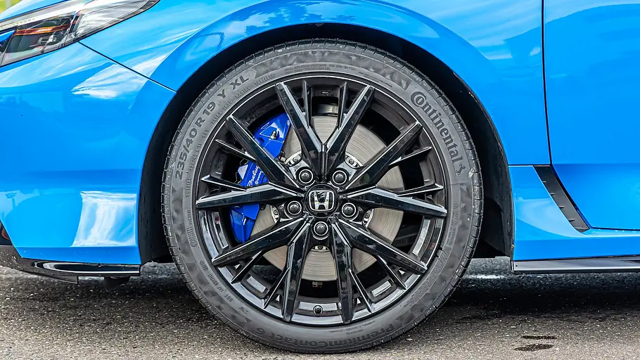 BMW 2er Coupé gegen Honda Prelude im Vergleichstest Das Vorderrad eines blauen Honda Prelude hat eine schwarze Mehrspeichenfelge, einen Continental-Reifen und einen blauen Bremssattel.