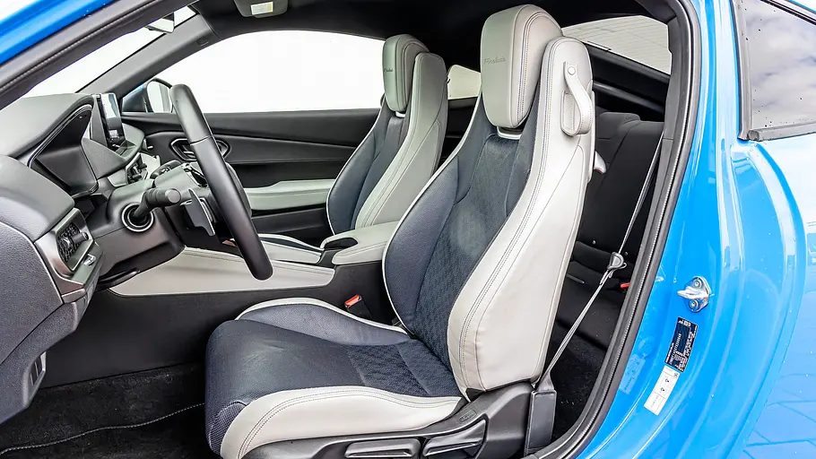 BMW 2er Coupé gegen Honda Prelude im Vergleichstest Die offene Fahrertür des Honda Prelude gibt den Blick auf zweifarbige Vordersitze, Lenkrad und Mittelkonsole frei.