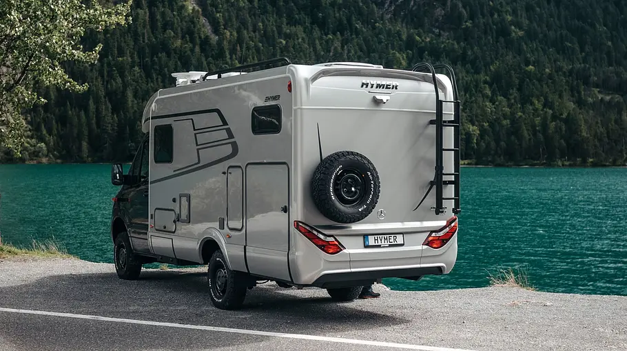 Der Hymer ML-T statisch von schräg hinten links an einem Seeufer.