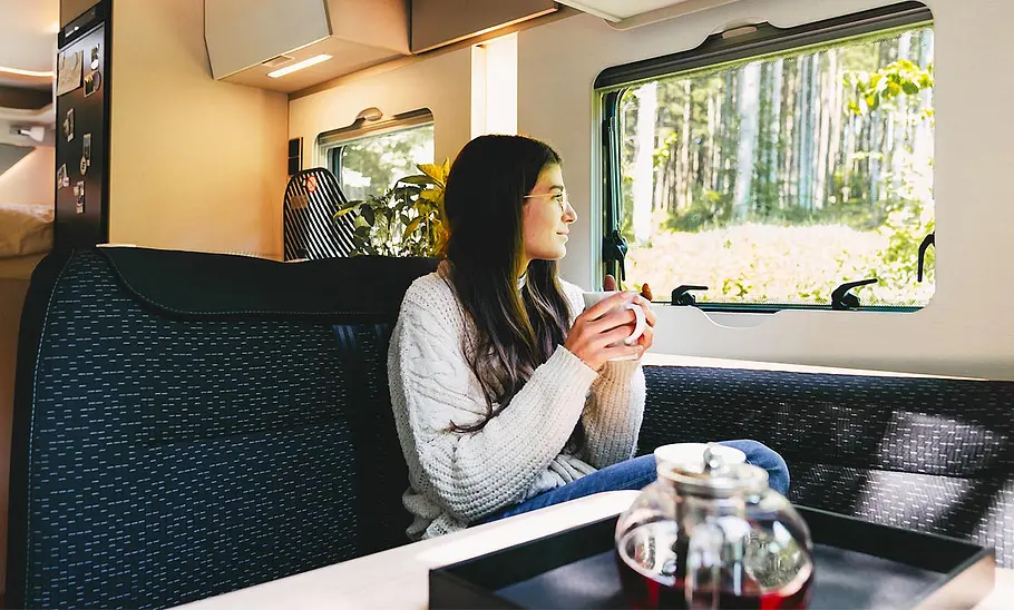 Die Innenaufnahme zeigt eine junge Frau in der Sitzgruppe des Hymer Tramp S 585 (2025).