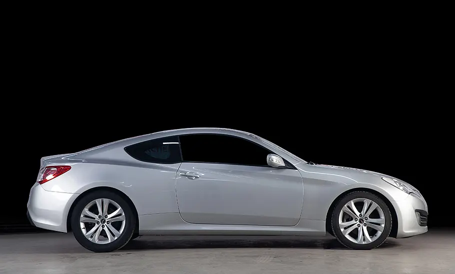 Vor einem schwarzen Hintergrund steht das Hyundai Genesis Coupe.