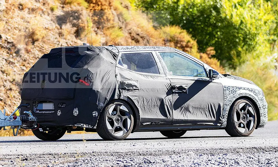 Blick von schräg hinten auf den fahrenden Erlkönig des Hyundai i20 (2026).