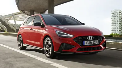 Der Hyundai i30 fährt in urbaner Umgebung auf einer Straße, von vorne fotografiert. - Foto: Hyundai