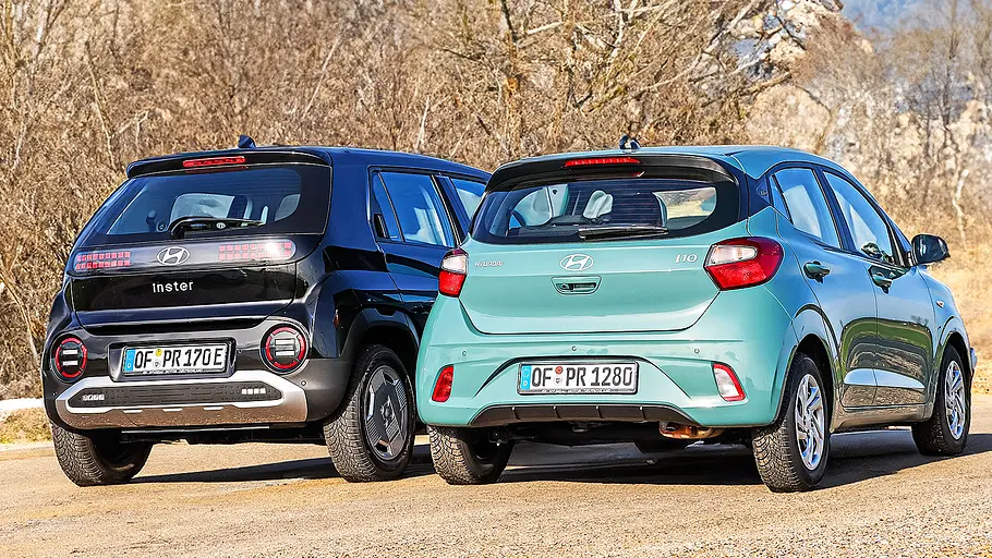 Blick von schräg hinten auf die beiden Kleinwagen Hyundai Inster und Hyundai i10.