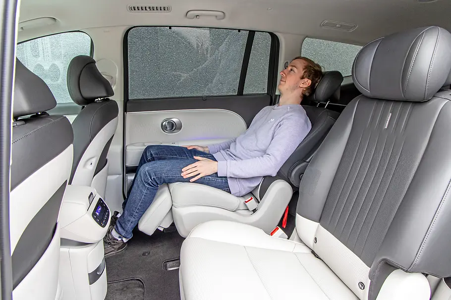 Hyundai Ioniq 9 Das Bild zeigt die zweite Sitzreihe im Hyundai Ioniq 9 und wie dort eine Person auf dem Liegesitz Platz genommen hat.