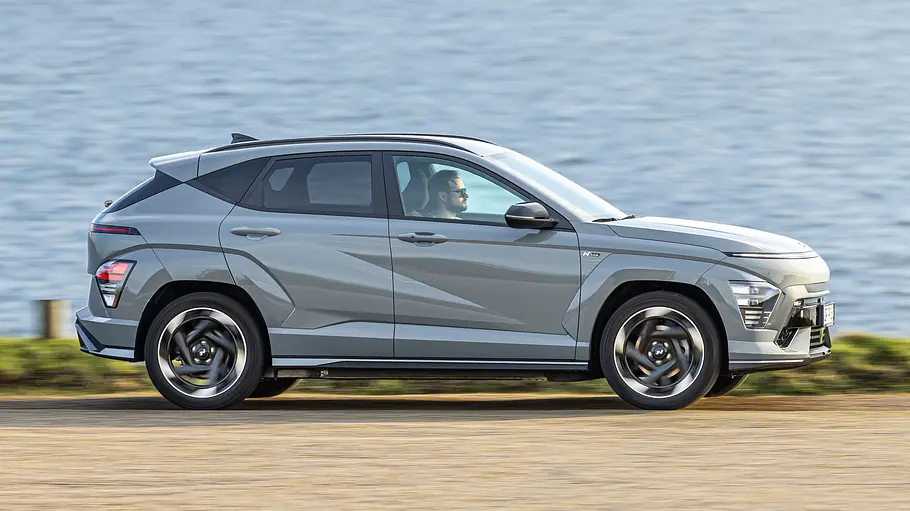 Hyundai Kona Elektro Der Hyundai Kona Elektro fahrend von der Seite fotografiert.