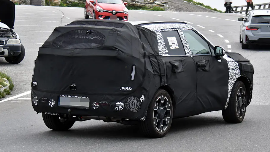 Hyundai Tucson (2027) Der Erlkönig des Hyundai Tucson (2027) fahrend auf einem Alpenpass von schräg hinten rechts.
