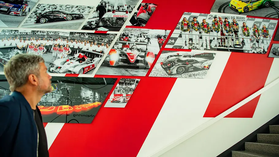Die mit Fotos gespickte Treppenwand von Audi Sport