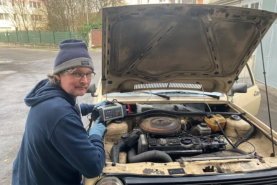 Ein Tester vor der geöffneten Motorhaube eines VW Polo.