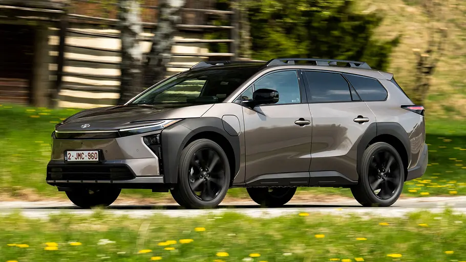 Toyota bZ4X Touring AWD auf einer Schotterpiste fahrend von der Seite.