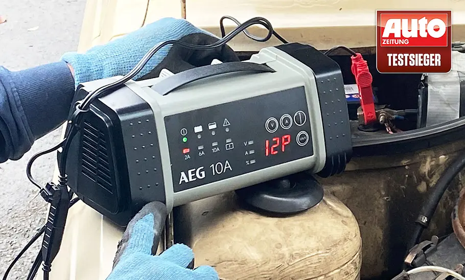 Das AEG Automotive 97024 Mikroprozessor-Ladegerät LT 10 in der Hand eines Testers.