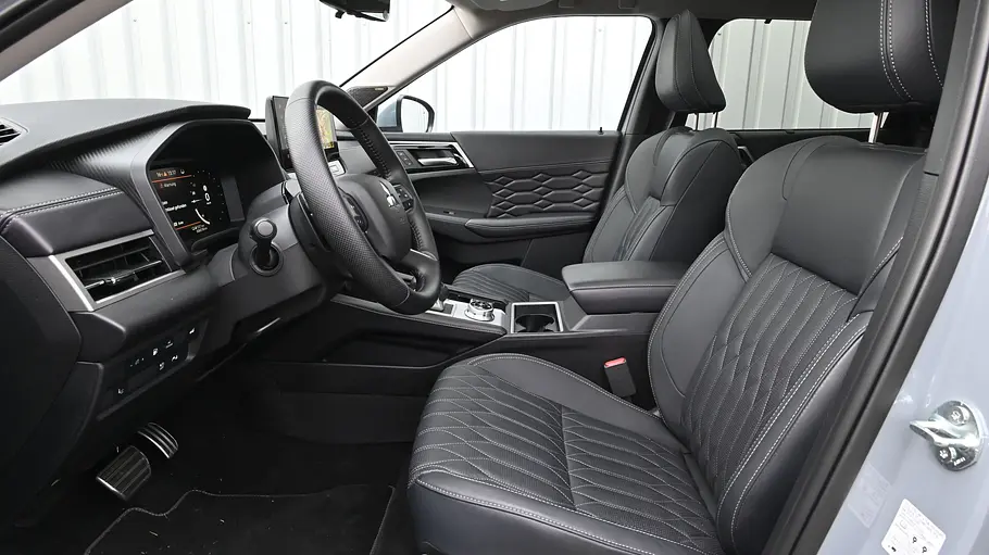Die Vordersitze und das Cockpit des Mitsubishi Outlander von der Seite fotografiert.
