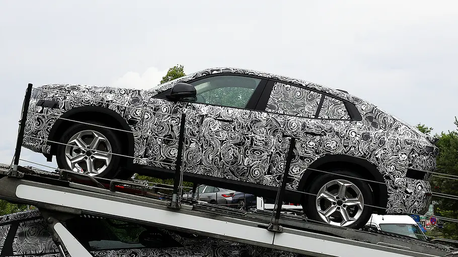 BMW X2 Facelift (2026) Blick von der Seite auf den Erlkönig des BMW X2 Facelift (2026), der auf einem Autotransporter steht.