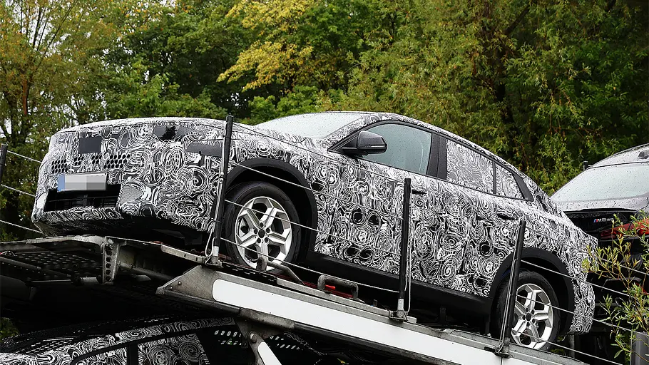 BMW X2 Facelift (2026) Blick von schräg vorne auf den Erlkönig des BMW X2 Facelift (2026), der auf einem Autotransporter steht.