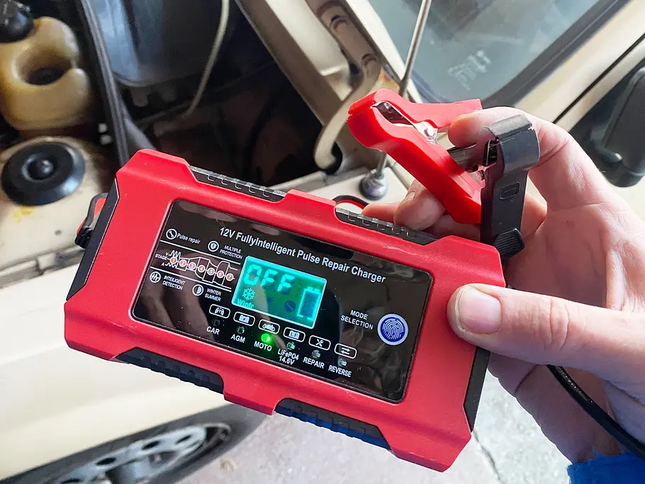 Das Hausprofi Kfz-Batterieladegerät in der Hand eines Testers,