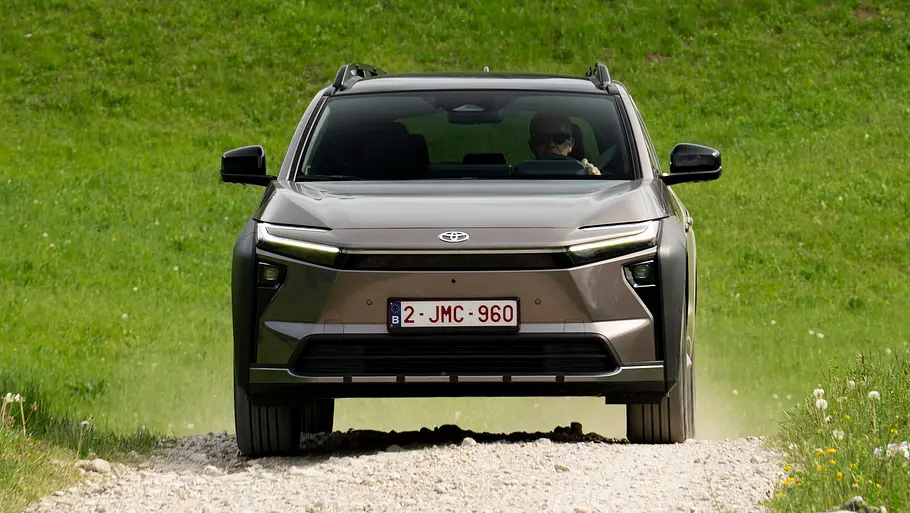 Toyota bZ4X Touring AWD von vorne, auf einer Schotterpiste fahrend.