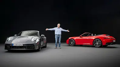 Der Redakteur Martin Urbanke steht mit dem Porsche 911 Carrera GTS Facelift & Porsche 911 Carrera Cabrio Facelift (2024) im Studio. - Foto: Porsche