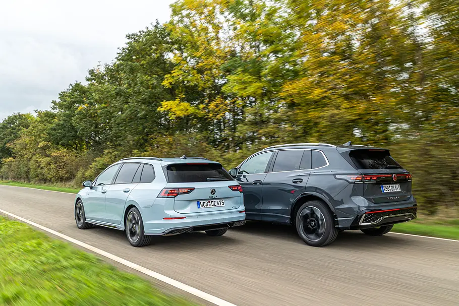 Der VW Golf Variant und der VW Tiguan fahhren auf der Landstraße nebeneinander her, fotografiert von schräg hinten.