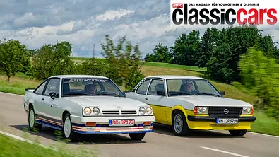 Der Opel Manta B i 200 und Opel Ascona B i 2000 fahren auf einer Straße, fotografiert von vorne schräg. - Foto: Hardy Mutschler