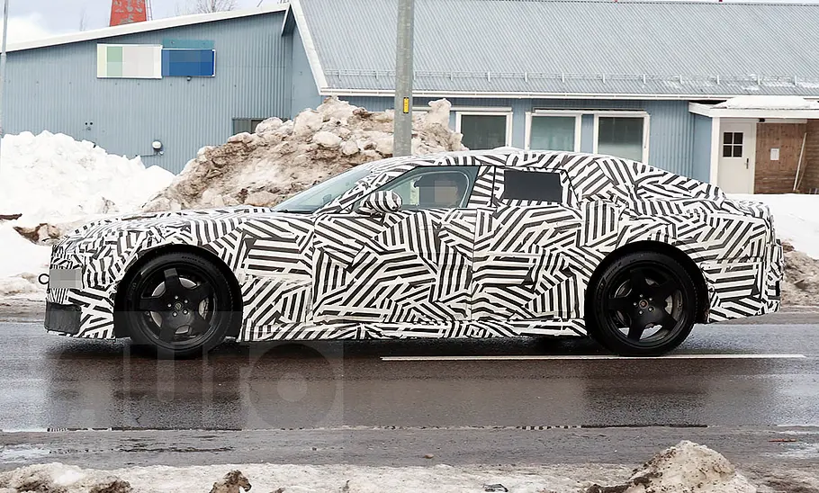 Neue Markenidentität für Jaguar Ein Erlkönig des neuen Jaguar-Modells fahrend auf einer Straße von der Seite.