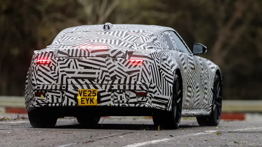 Der fahrende Prototyp Jaguar Type 01 auf einer Straße von hinten.
