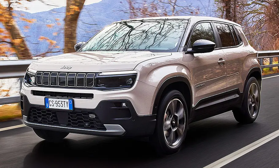 Jeep Avenger e-Hybrid (2024) Der Jeep Avenger e-Hybrid (2024) fahrend auf einer Landstraße, fotografiert von schräg vorne.