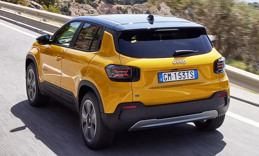 Jeep Avenger Elektro (2023) Jeep Avenger Elektro (2023) fahrend auf einer Landstraße von schräg hinten fotografiert.