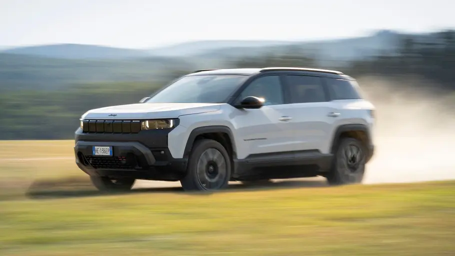 Der Jeep 4xe Elektro fährt auf einem Feldweg, von vorne links fotografiert.