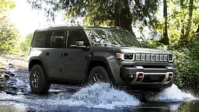 Blick von schräg vorne auf den Jeep Recon (2026), der durch ein flaches Gewässer fährt. - Foto: Jeep