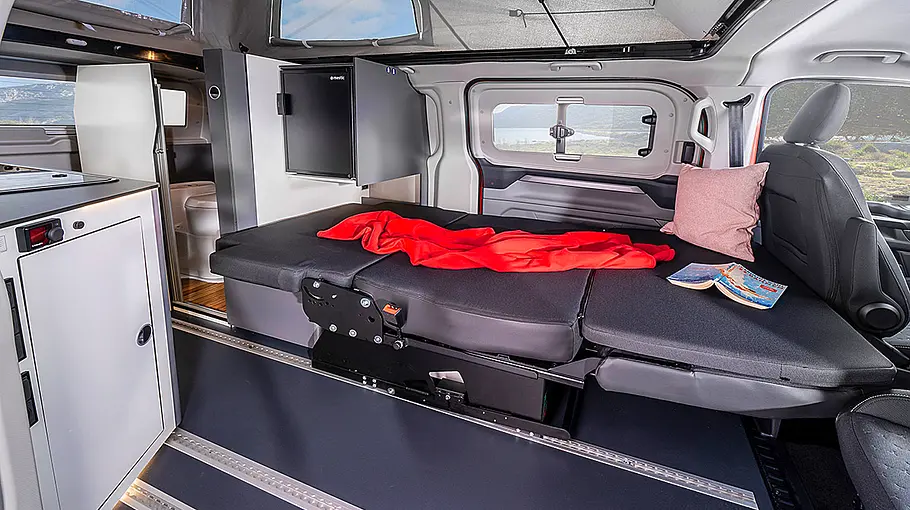 Das Bild zeigt den Wohnraum des Karmann Duncan 550 als Schlafraum. Die Sitzbank ist zum Bett umgebaut.