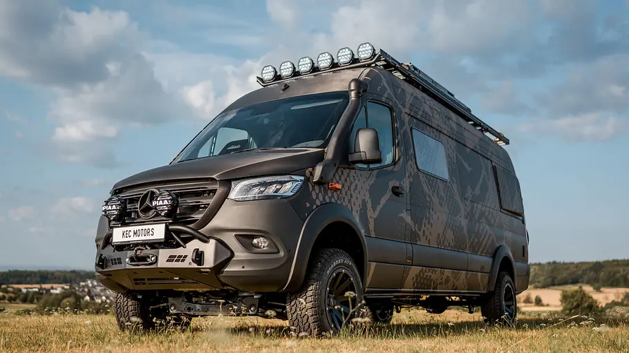 KEC Mountaineer Grand Expedition Die Außenaufnahme zeigt den KEC Mountaineer Grand Expedition auf Mercedes-Basis von schräg vorne unten fotografiert auf einem Acker.