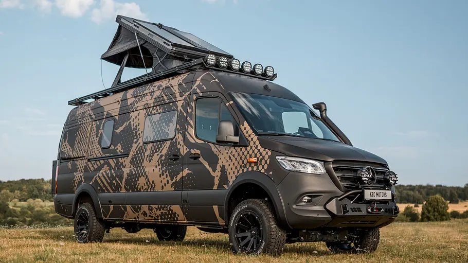 KEC Mountaineer Grand Expedition Die Außenaufnahme zeigt den KEC Mountaineer Grand Expedition auf Mercedes-Basis mit montiertem Dachzelt von schräg seitlich fotografiert auf einem Acker.