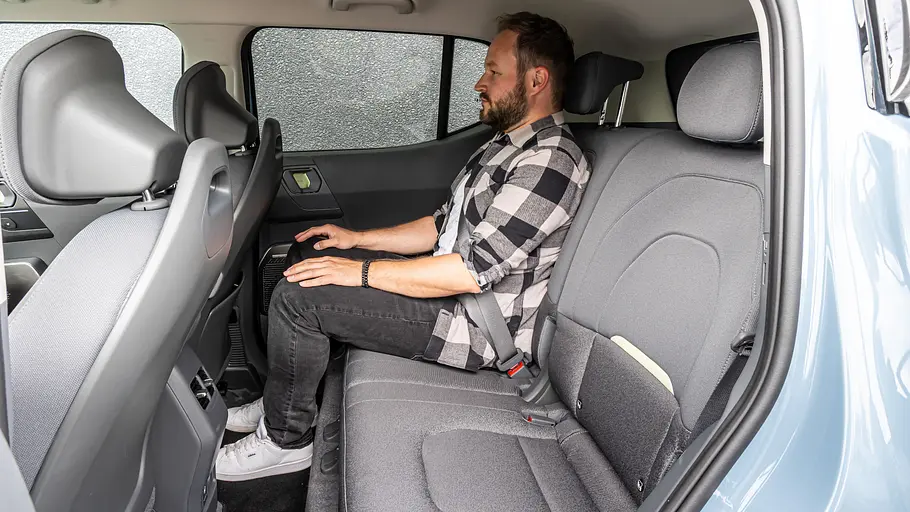 Kia EV2 Einzeltest Eine Person auf den Rücksitzen des Kia EV2 durch die geöffnete Hintertüre fotografiert.
