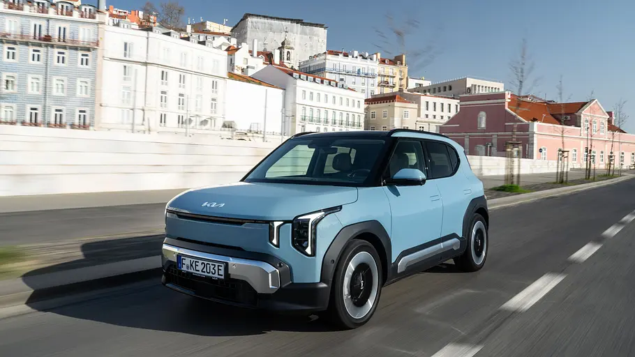 Der Kia EV2 fahrend auf einer Straße von schräg vorne.