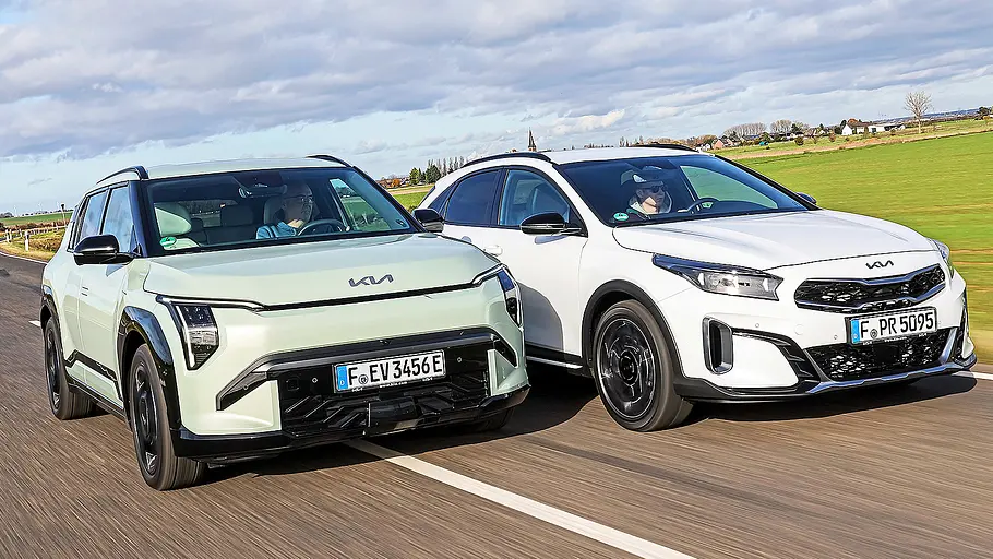 Blick von schräg vorne auf die beiden fahrenden Kompaktwagen Kia EV3 und Kia XCeed.