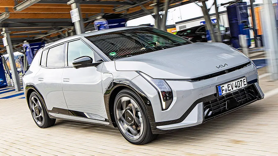 Blick von schräg vorne auf den fahrenden Kia EV4.