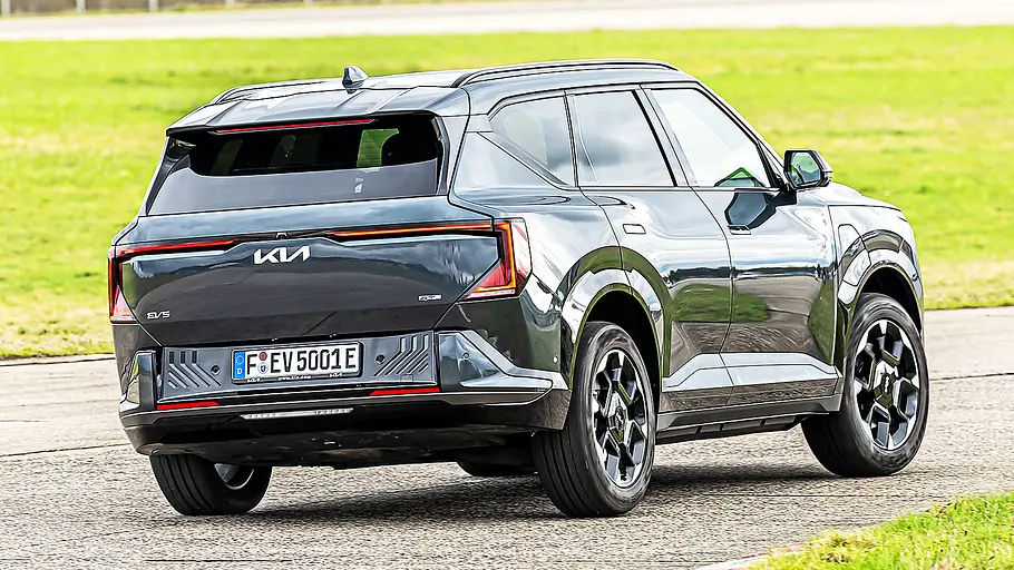 Blick von schräg hinten auf das fahrende Elektro-SUV Kia EV5.