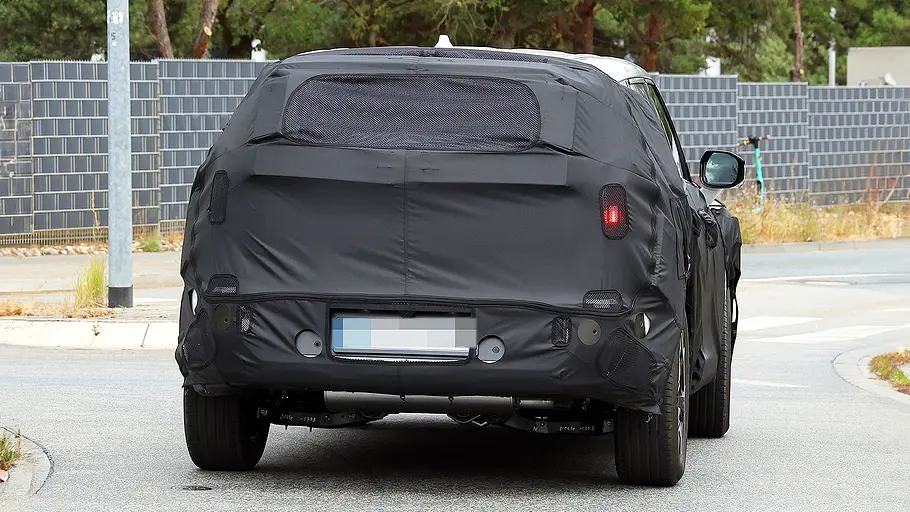 Blick von hinten auf den fahrenden Erlkönig des Kia EV5 Facelift (2026).