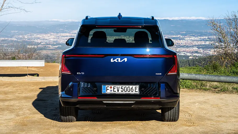 Der Kia EV5 steht auf einem Parkplatz, von hinten fotografiert.