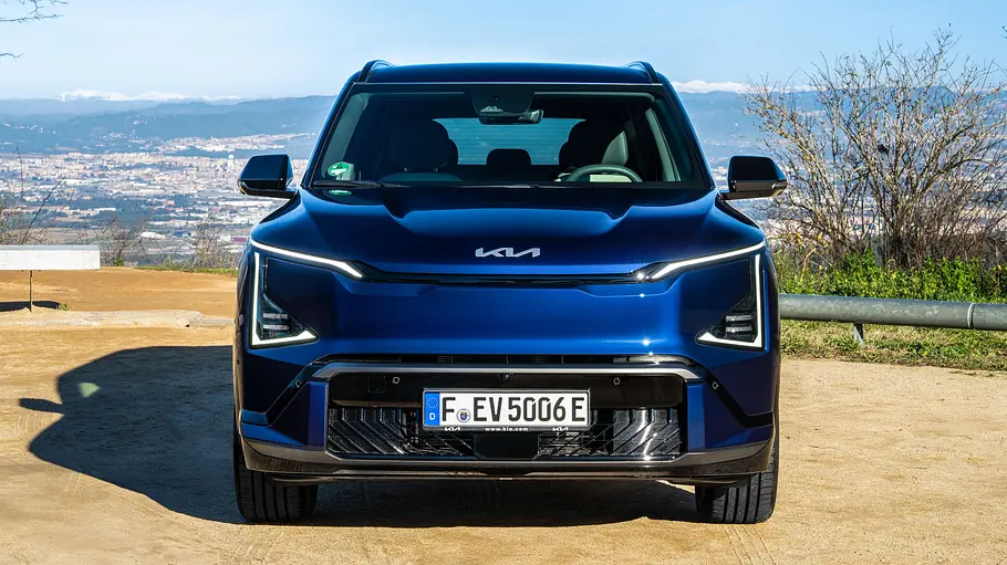 Der Kia EV5 steht auf einem Parkplatz, von vorne fotografiert.