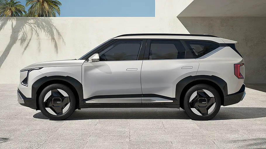 Der Kia EV5 (2025) steht in einer Einfahrt, von links fotografiert.