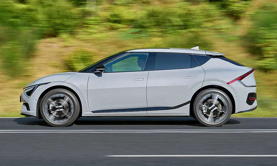 Kia EV6 Facelift (2024) Das Kia EV6 Facelift (2024) als GT-line, fahrend auf der Landstraße, von der Seite fotografiert.