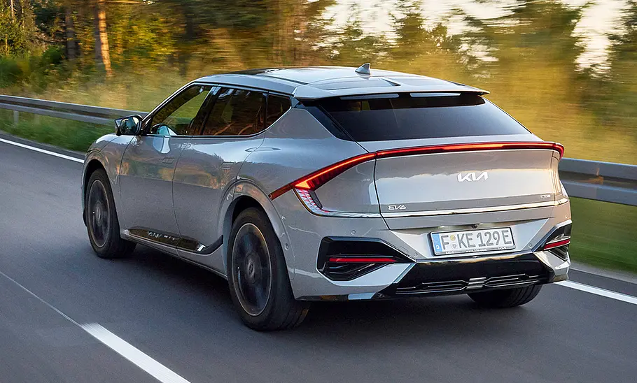 Kia EV6 Facelift (2024) Das Kia EV6 Facelift (2024) als GT-line, fahrend auf der Landstraße, von schräg hinten fotografiert.