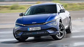 Das Kia EV6 GT Facelift (2025) driftend um eine Kurve, fotografiert von vorne. - Foto: Kia