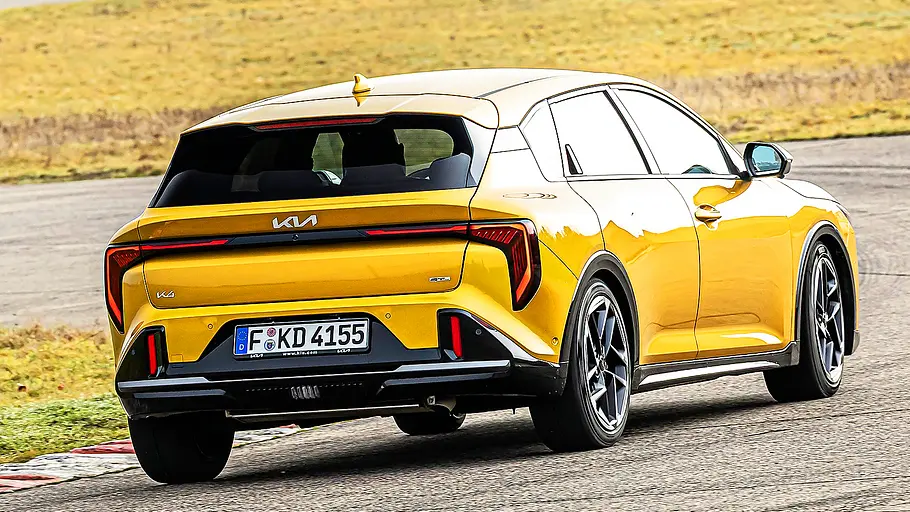 Blick von schräg hinten auf den fahrenden Kia K4.