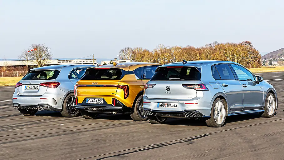 Blick von schräg hinten auf die drei nebeneinander fahrenden Kompakten Mercedes A-Klasse, Kia K4 und VW Golf.
