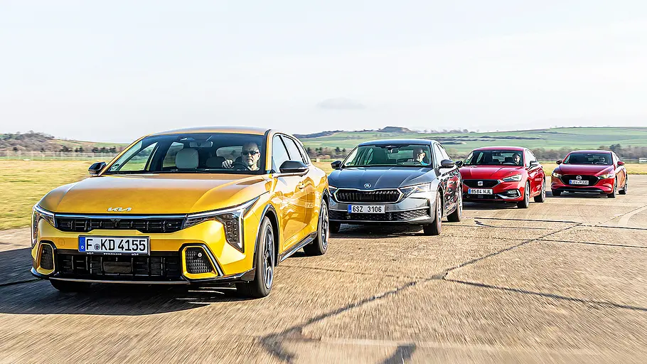 Kia K4/Skoda Octavia/Seat Leon/Mazda3 Blick von schräg vorne auf die vier fahrenden Kompakten Kia K4, Skoda Octavia, Seat Leon und Mazda3.