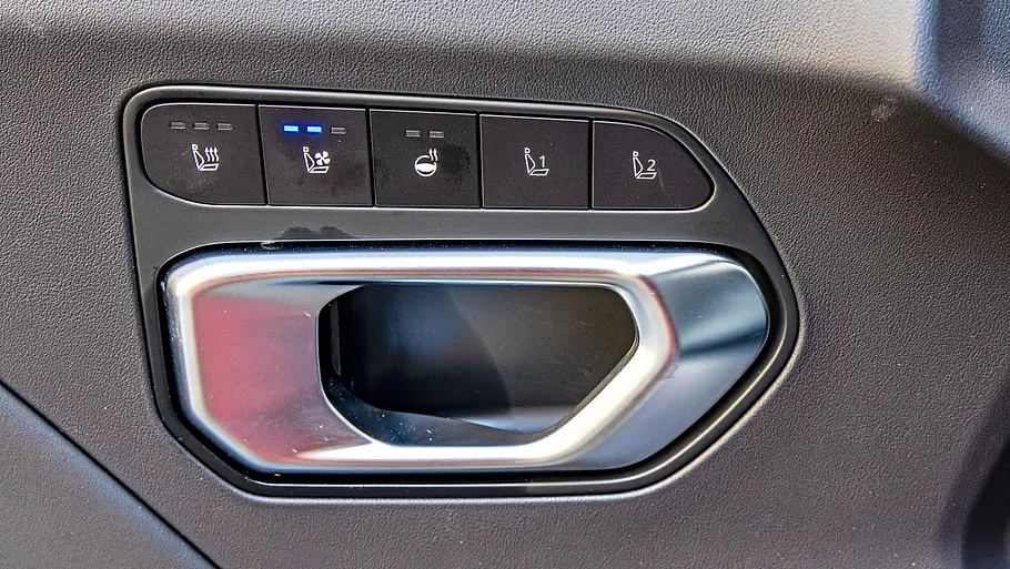 Die Knopfleiste für Sitzheizung und -belüftung über dem inneren Türgriff an der Fahrertüre des Kia K4 Sportswagon.