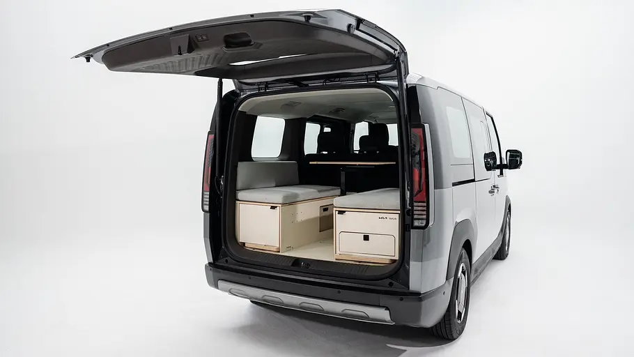 Der Kia PV5 mit VanLab-Campingbox mit geöffneter Heckklappe von schräg hinten rechts.