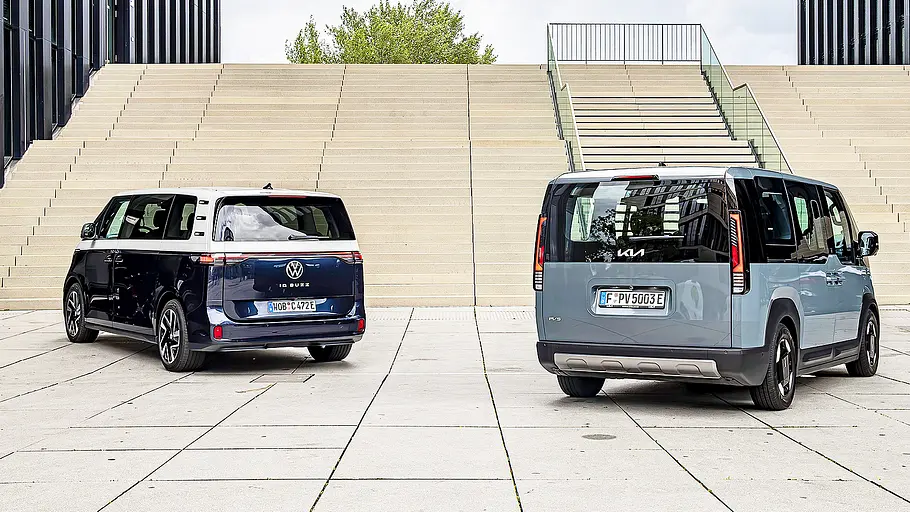 Blick von schräg hinten auf die elektrischen Kleinbusse VW ID. Buzz und Kia PV5.